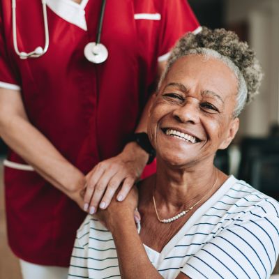 Smiling Jacksonville medical weight loss patient with her provider in red scrubs after a consultation