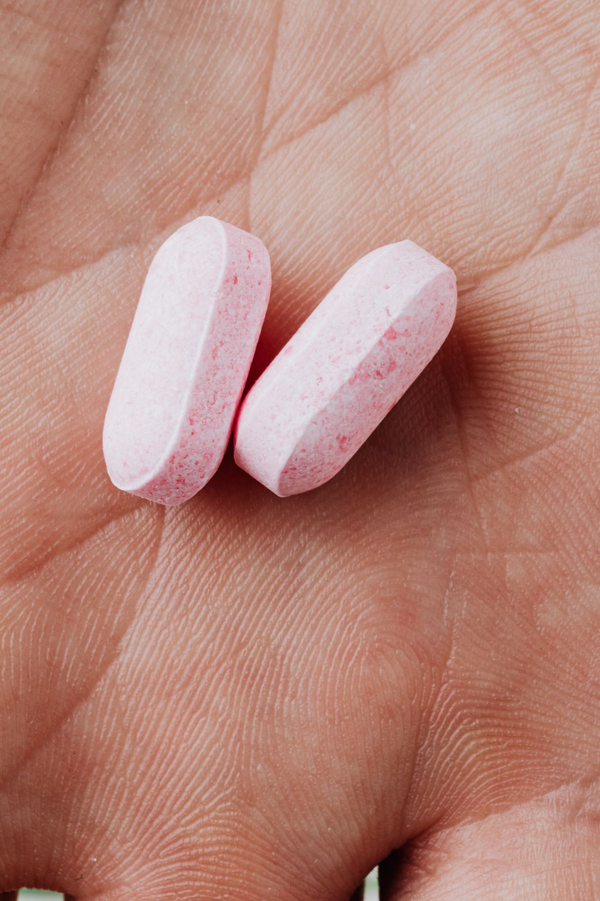 Two bioidentical hormone tablets in an open palm — bioidentical vs synthetic hormones