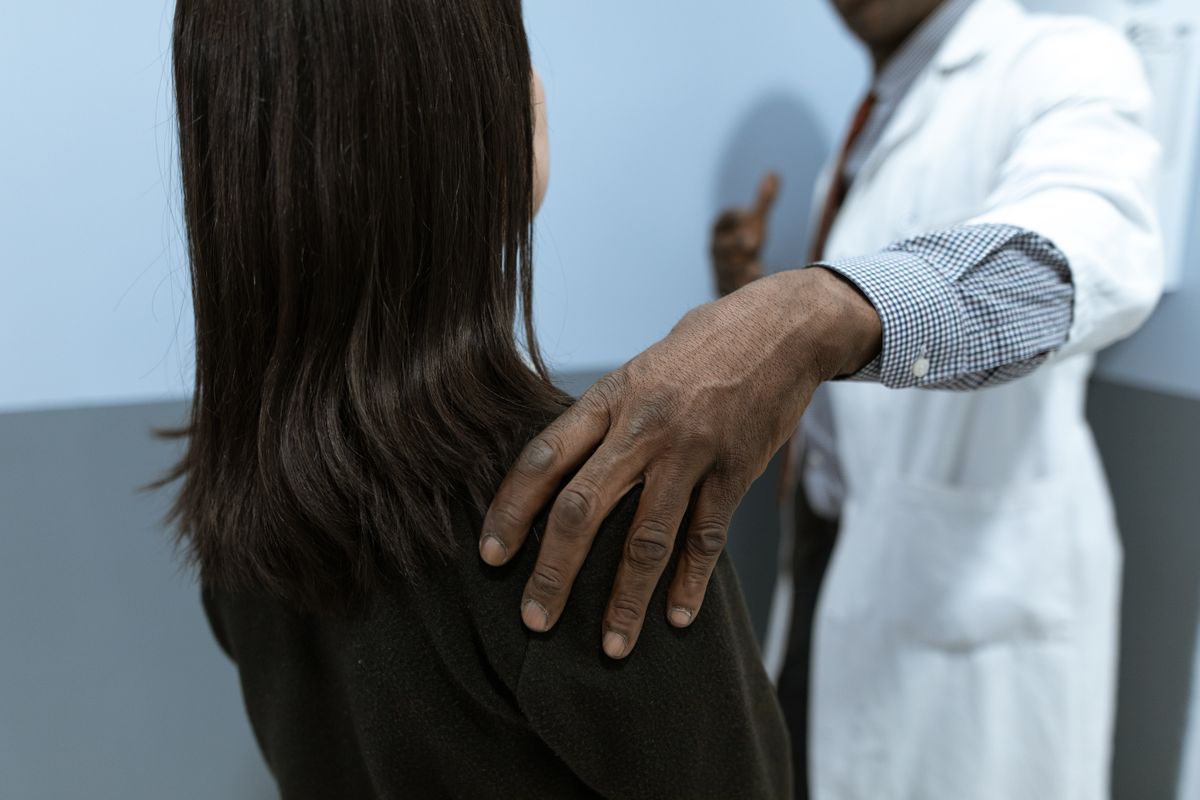 Doctor placing a reassuring hand on a patient's shoulder during a consultation — choosing a pellet therapy provider