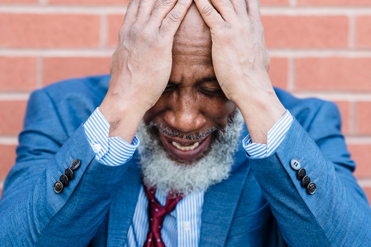 Distressed middle-aged man holding his head — low testosterone and anxiety