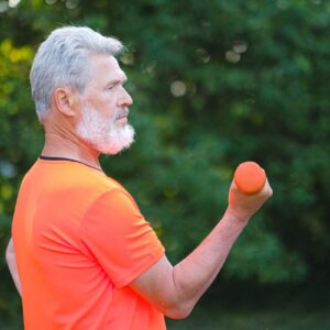 Active middle-aged man exercising with dumbbells — supporting testosterone and vitality