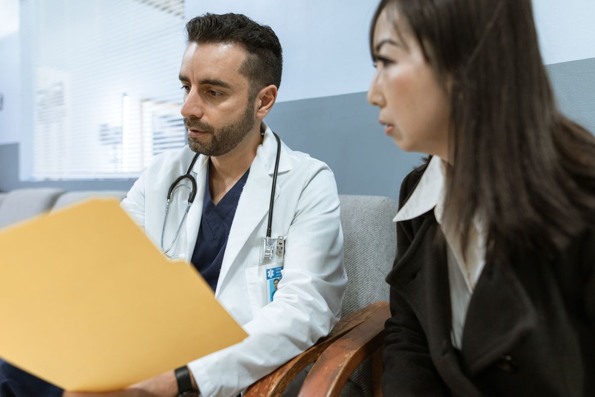 Doctor reviewing a chart with a patient — TRT clinic vs primary care doctor